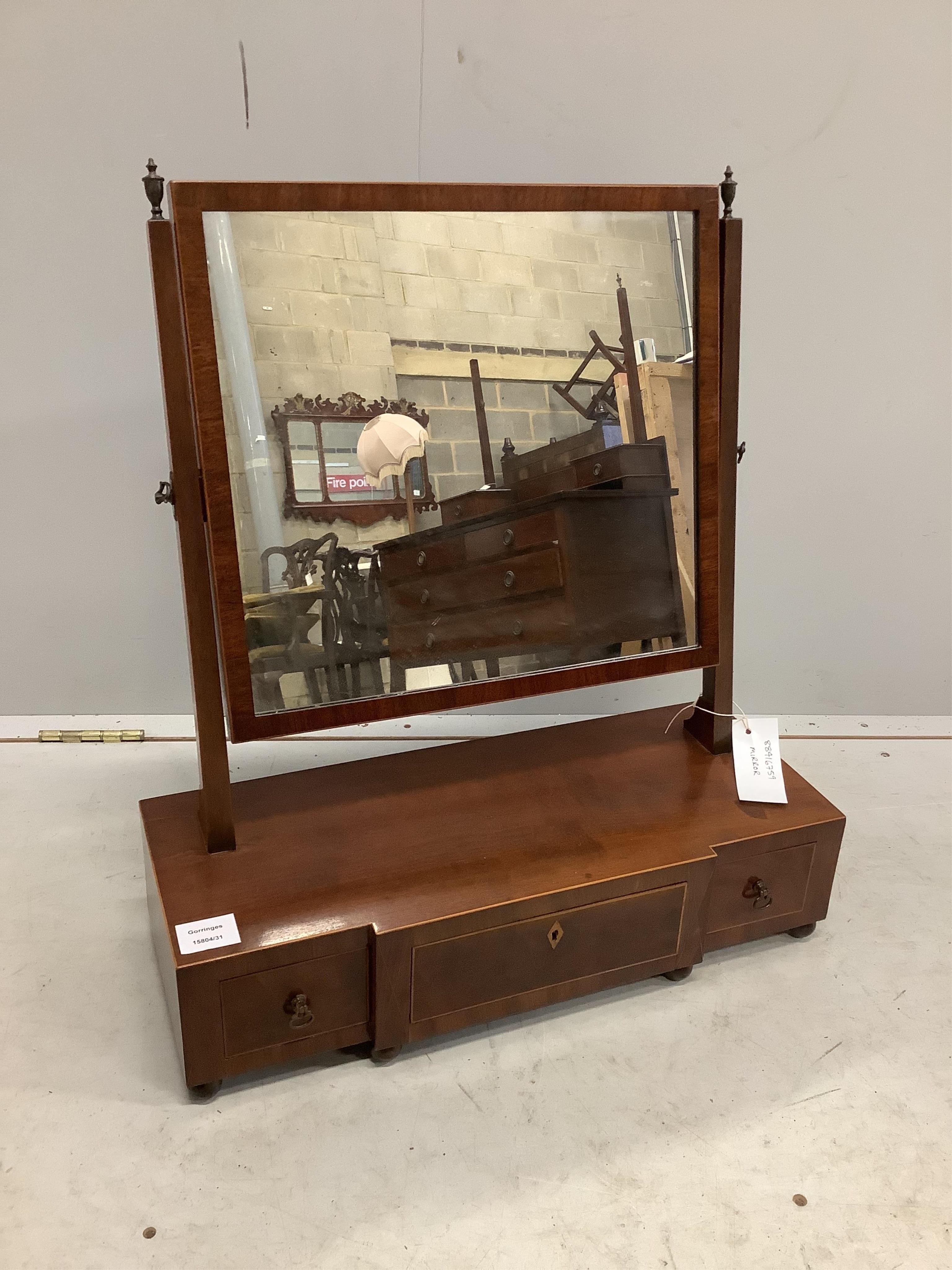 A George III mahogany toilet mirror with rectangular plate on breakfront three drawer box base, width 55cm, depth 22cm, height 62cm. Condition - fair